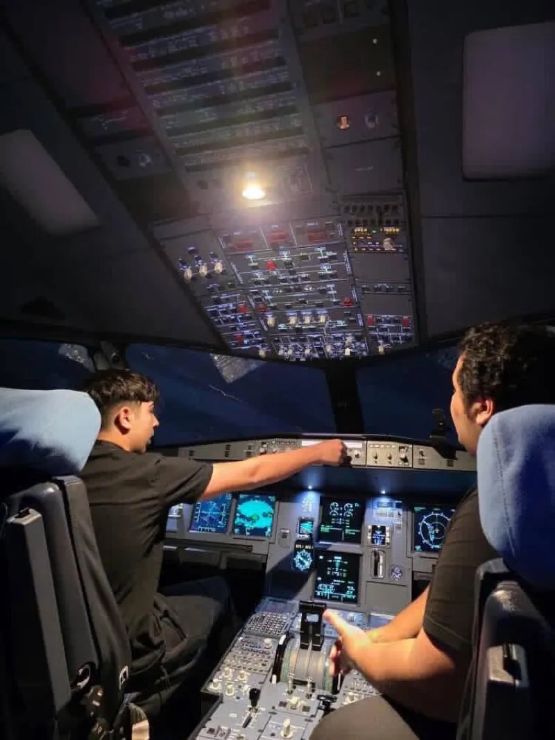 Two pilots flying the Airbus A320 simulator at night