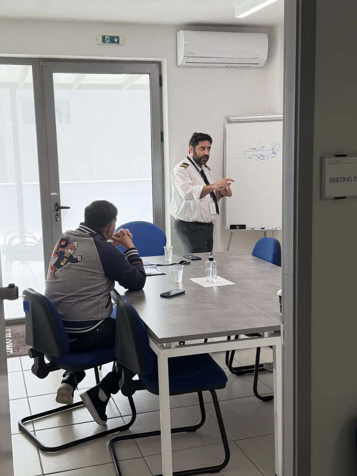 Pilot reaching for the overhead panel during pre-flight checks